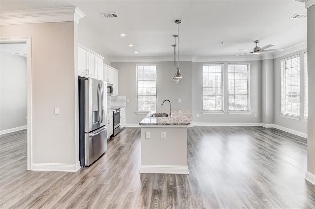 a kitchen with kitchen island wooden floors appliances and cabinets