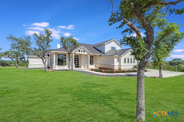 a front view of a house with yard and green space