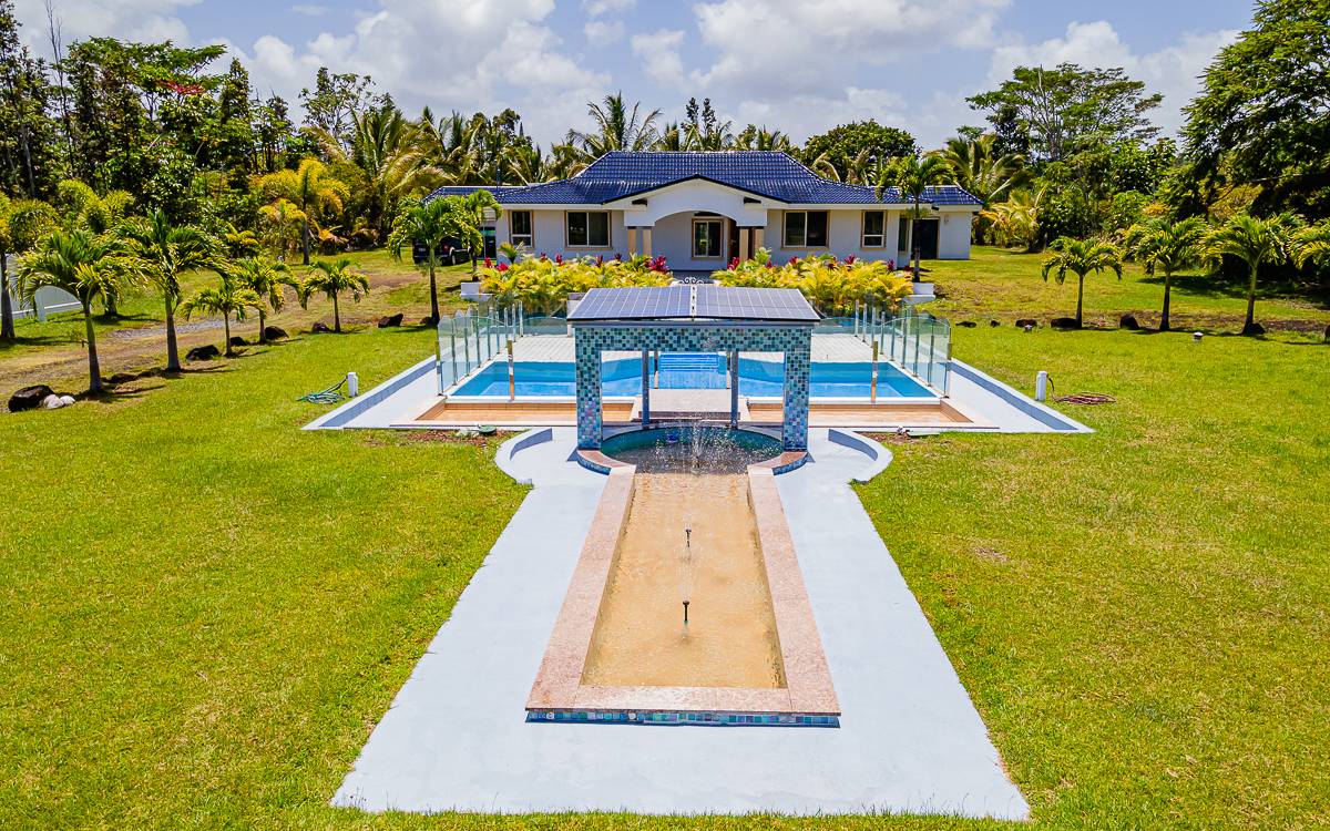 a view of a swimming pool with lawn chairs under an umbrella