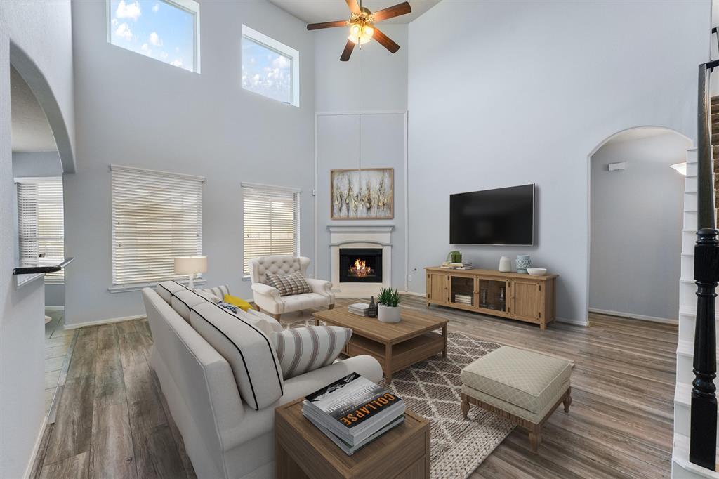 a living room with furniture a flat screen tv and a fireplace