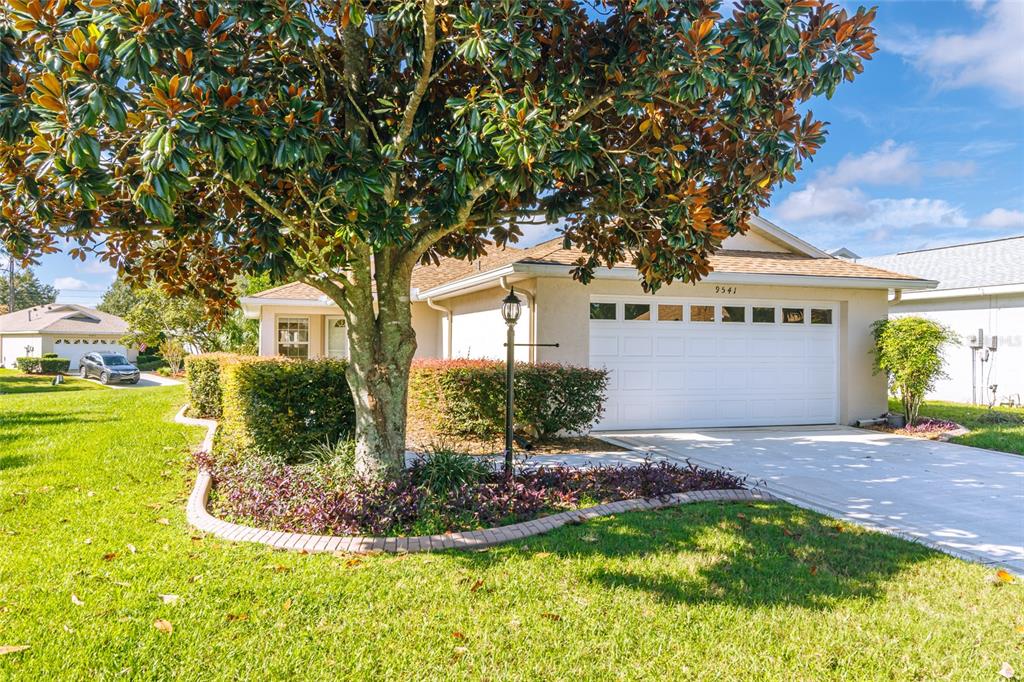 a front view of a house with a yard garage and outdoor seating