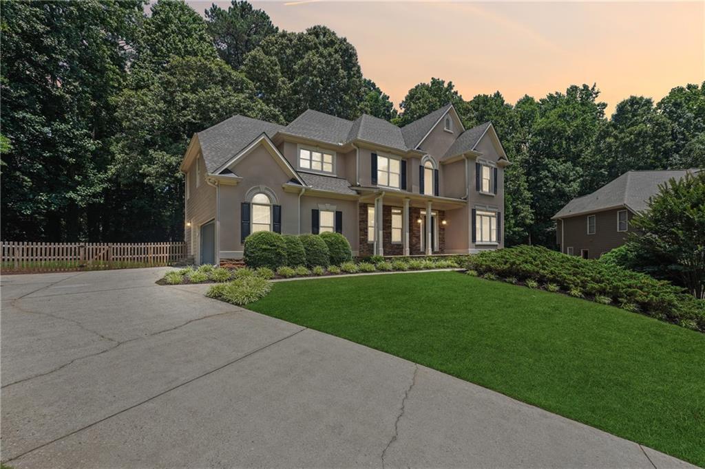 a front view of a house with a garden and yard