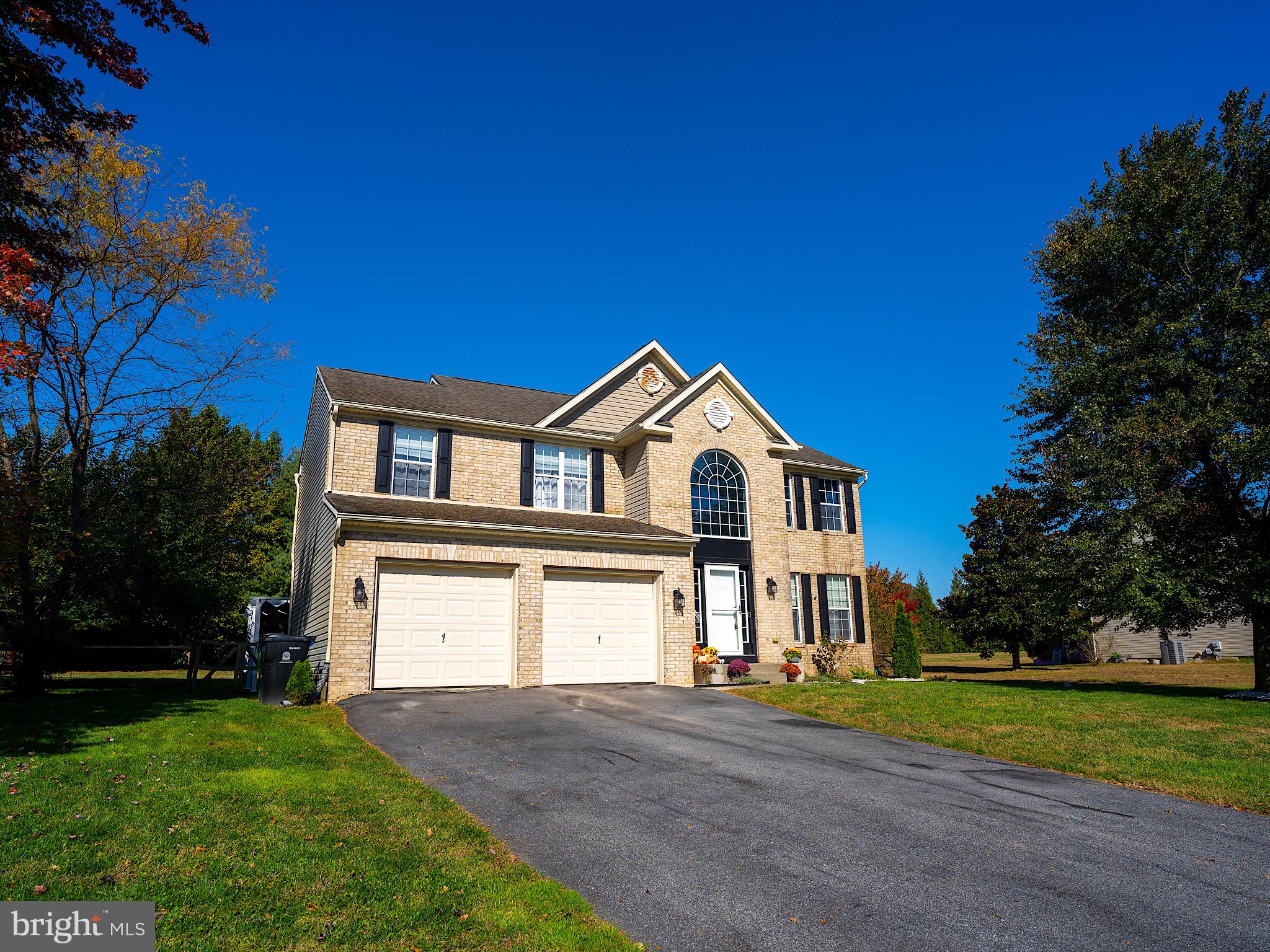 a view of a house with a yard and large tree