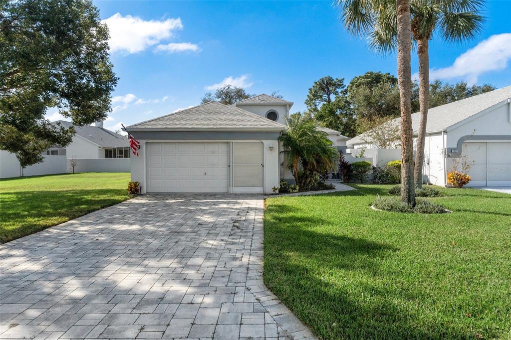 a front view of a house with a yard and palm trees