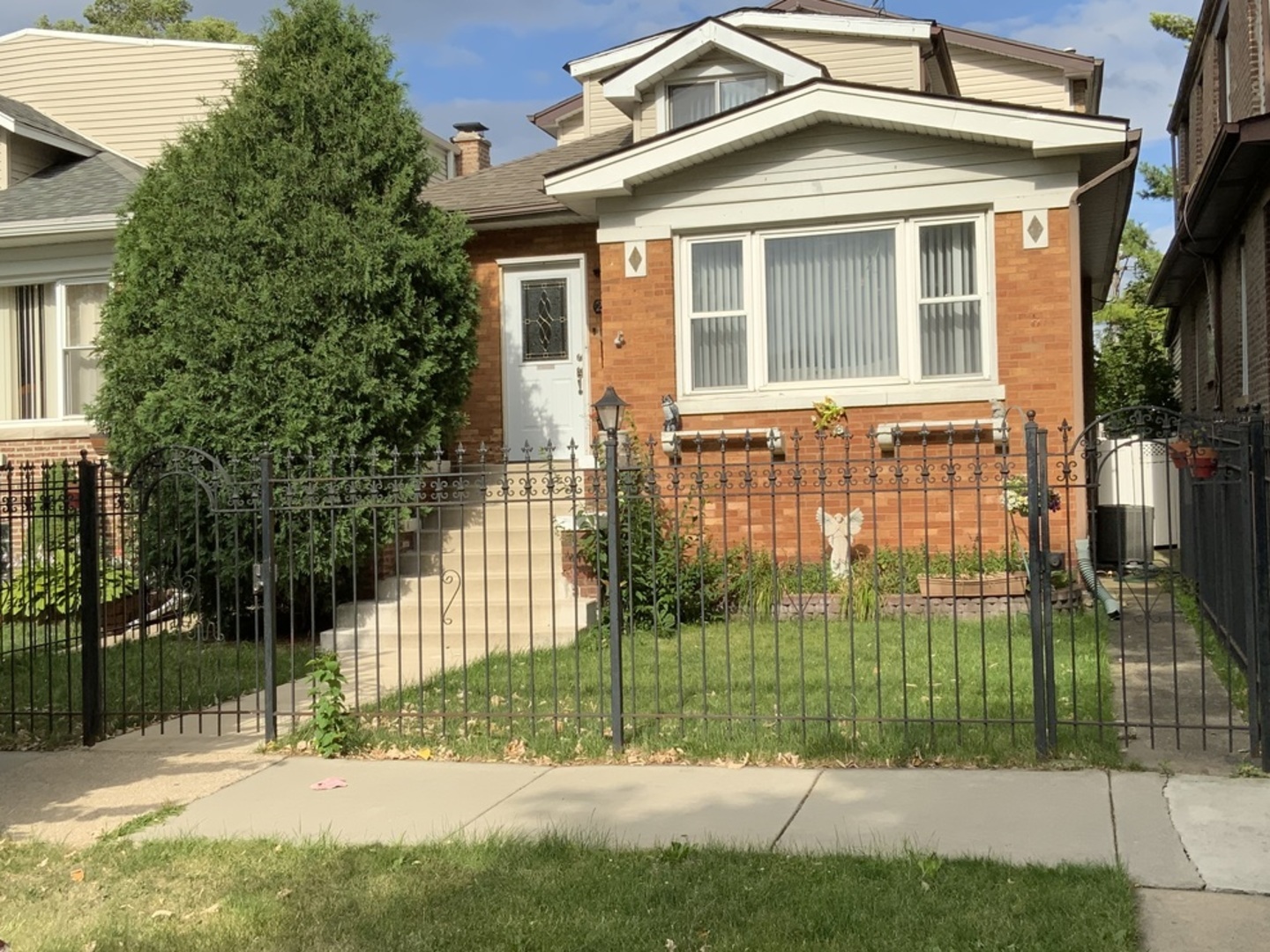 a view of a brick house with a yard in front of it