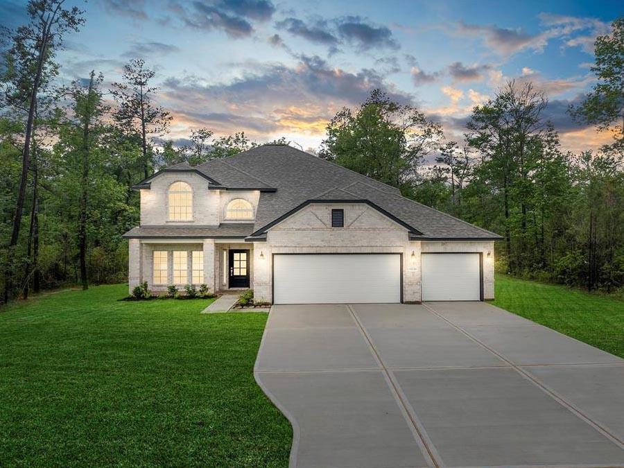 a view of a house with a big yard and large trees