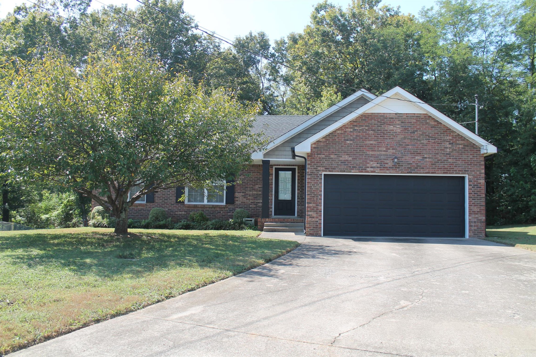 a front view of a house with yard and trees