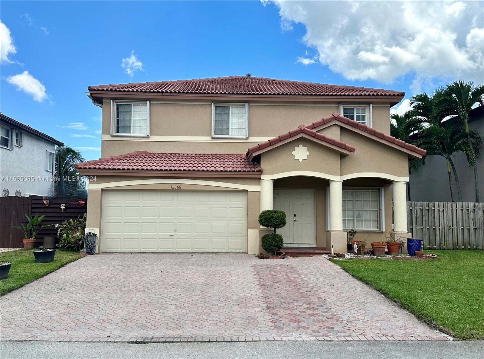 a front view of a house with a garden and garage