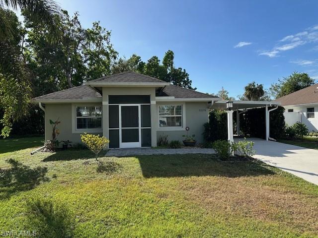 View of front of home with a carport and a front yard