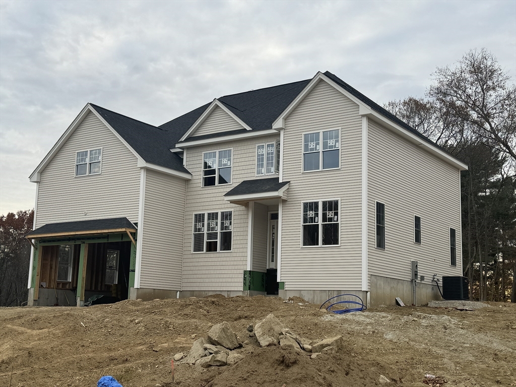 a front view of a house with a tree