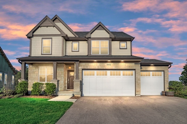 a front view of a house with a yard and garage