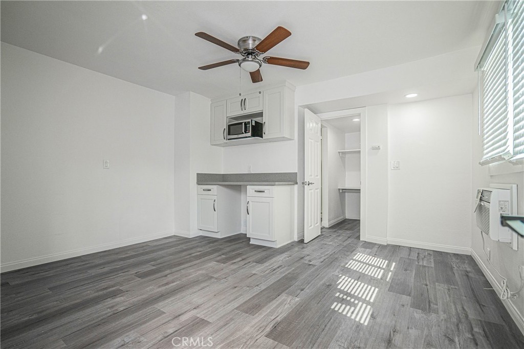 a view of empty room with wooden floor and ceiling fan