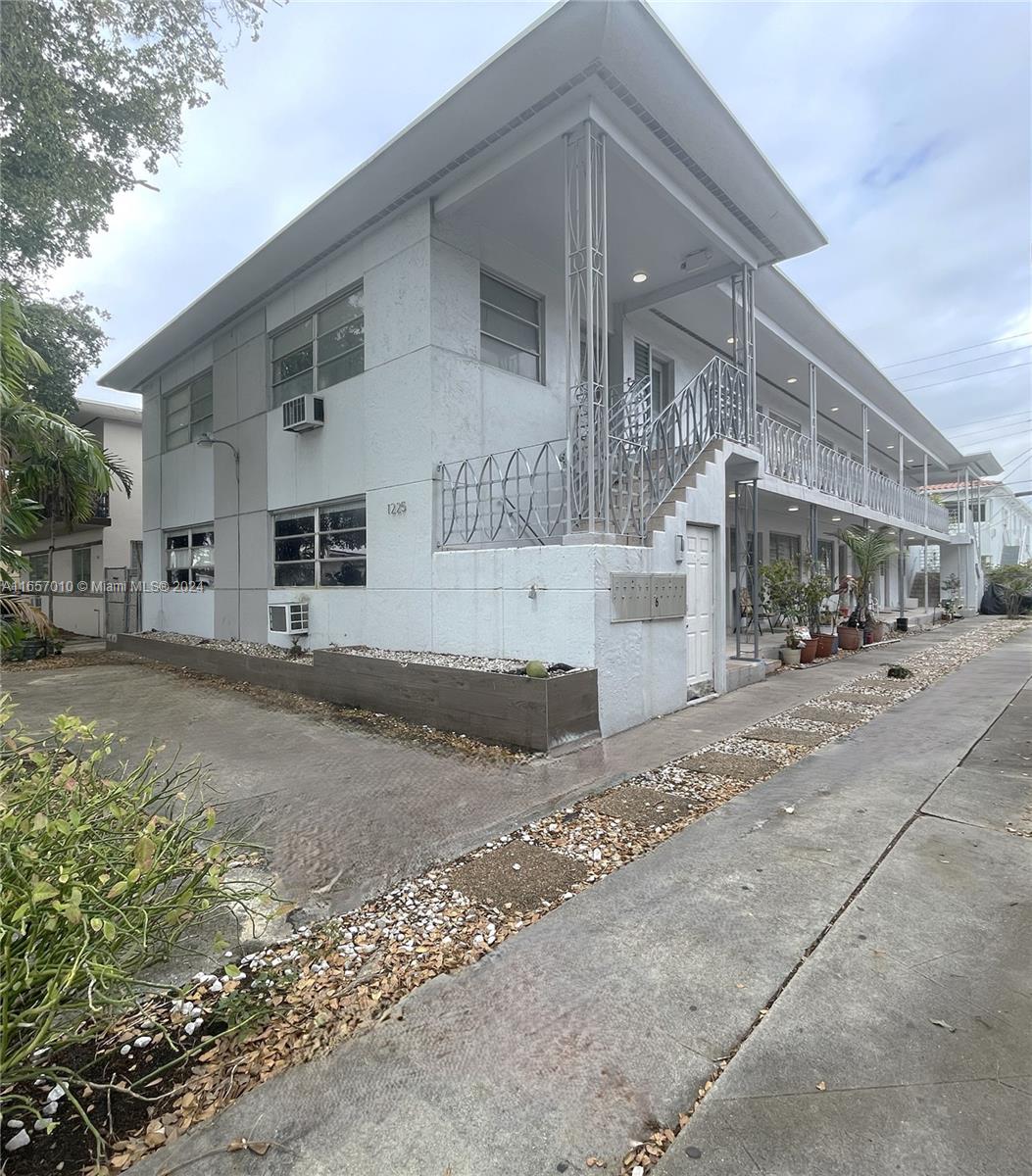 a view of a white house with a street