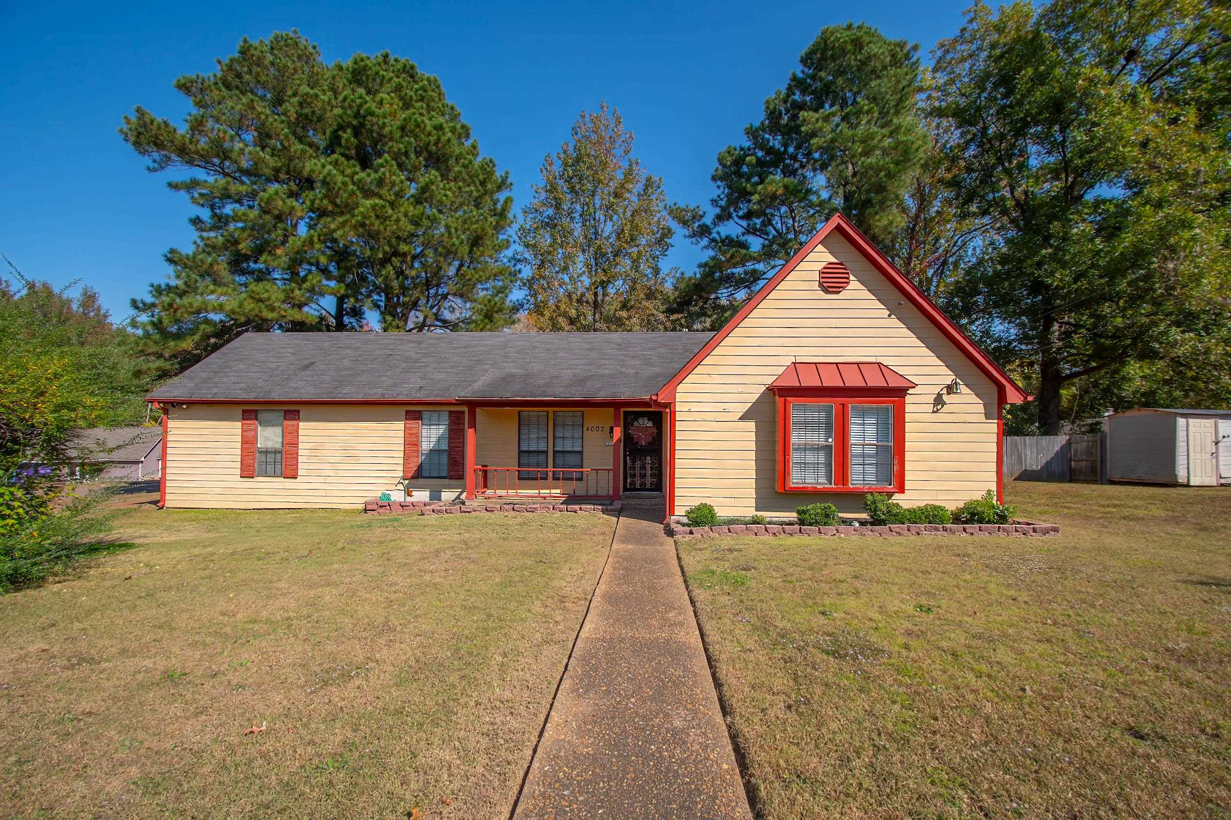 View of front of house with a storage unit and a front lawn