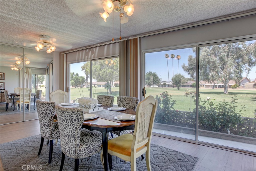 a view of a dining room with furniture large windows and wooden floor