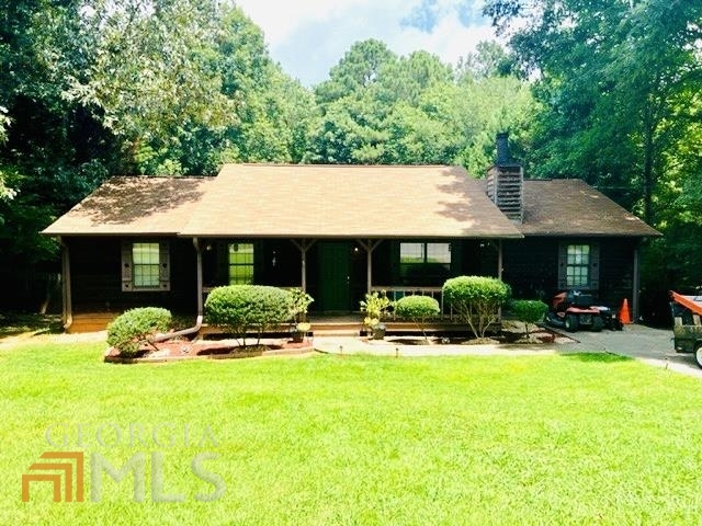 a front view of a house with yard and green space