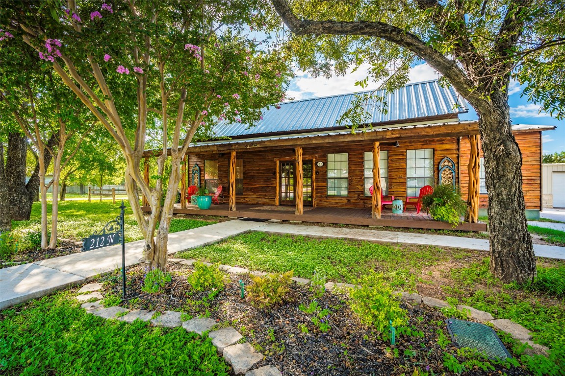 a view of a house with backyard and a tree