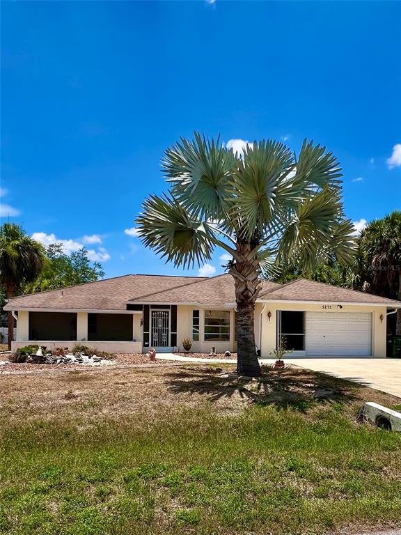 a front view of house with yard and trees in the background