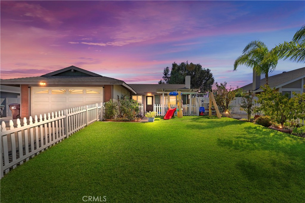 a view of a house with a yard and a garage