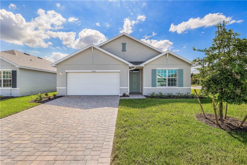 Ranch-style home featuring a front lawn and a garage