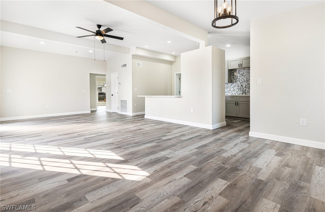 a view of a livingroom with a furniture wooden floor and a ceiling fan