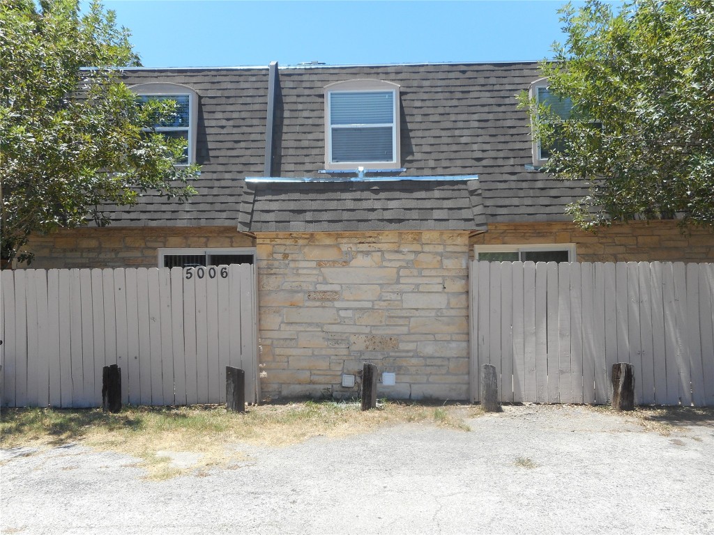 a view of a brick house with a wooden fence