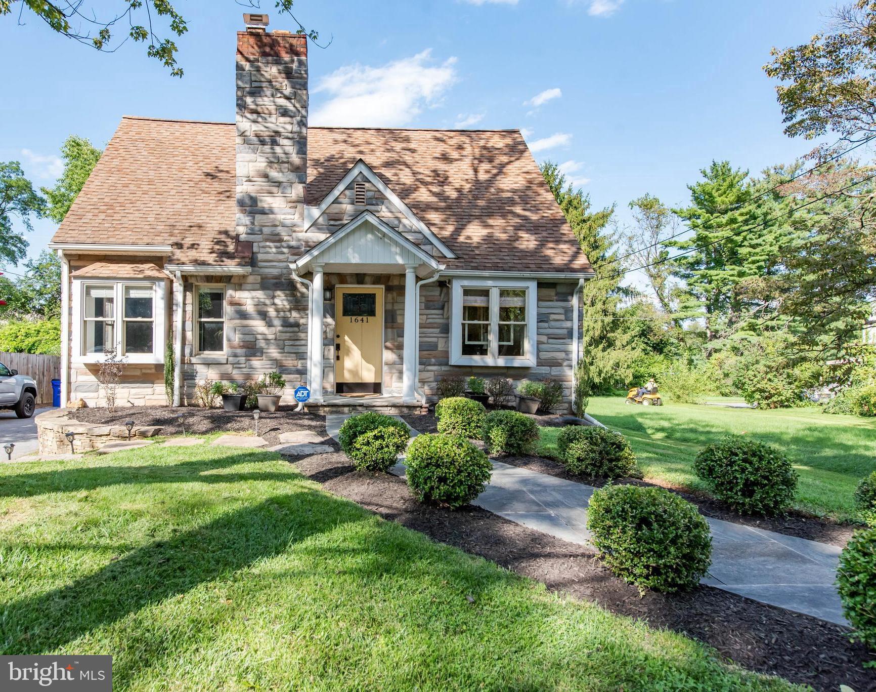 a front view of a house with a yard and potted plants