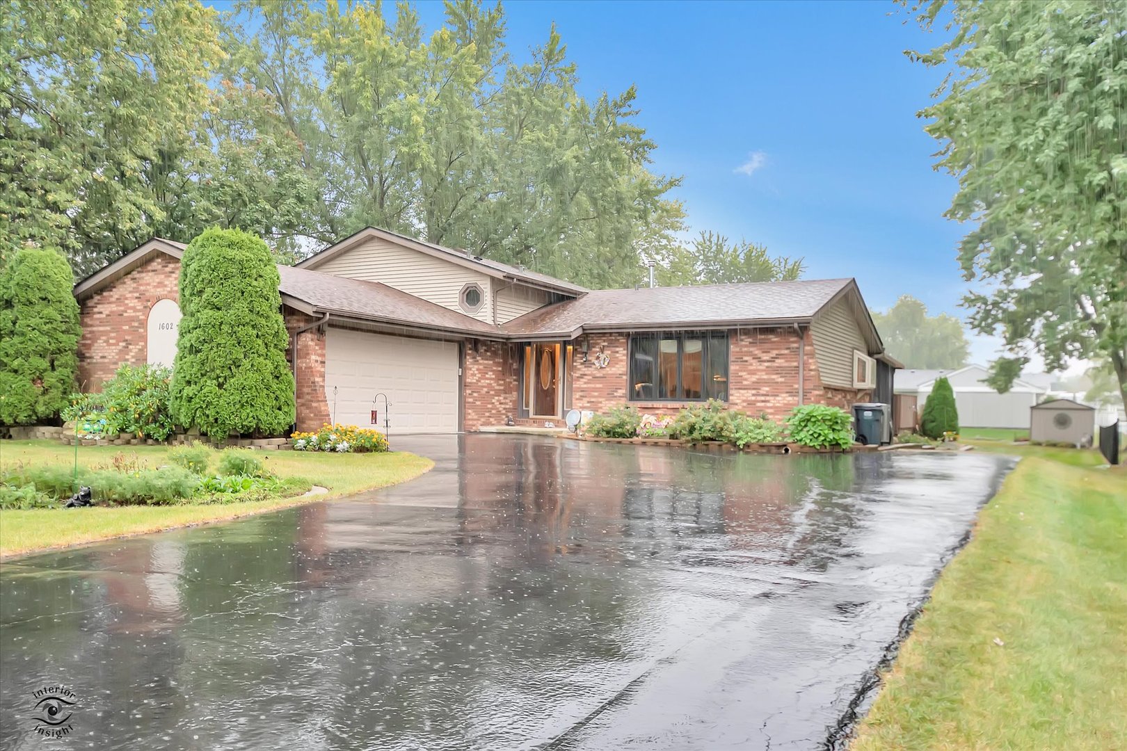 a front view of a house with a yard and lake view