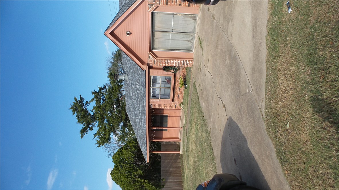 View of front of home with a front lawn and a gara