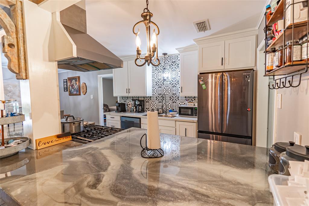 a kitchen with stainless steel appliances granite countertop a sink a stove and a refrigerator