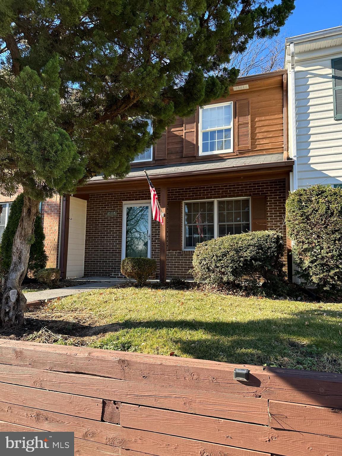 a view of a house with a yard and large tree