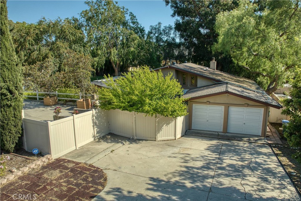 a view of a house with a yard and large tree