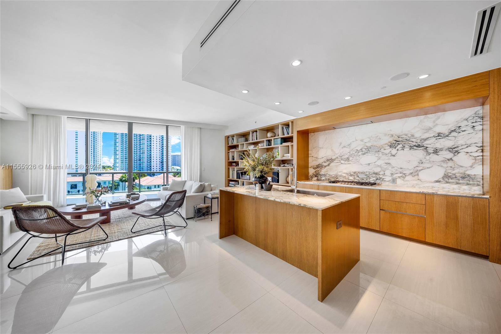 a living room with stainless steel appliances furniture and a large window