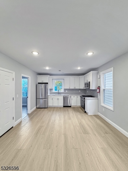 a view of a kitchen with a sink and a refrigerator