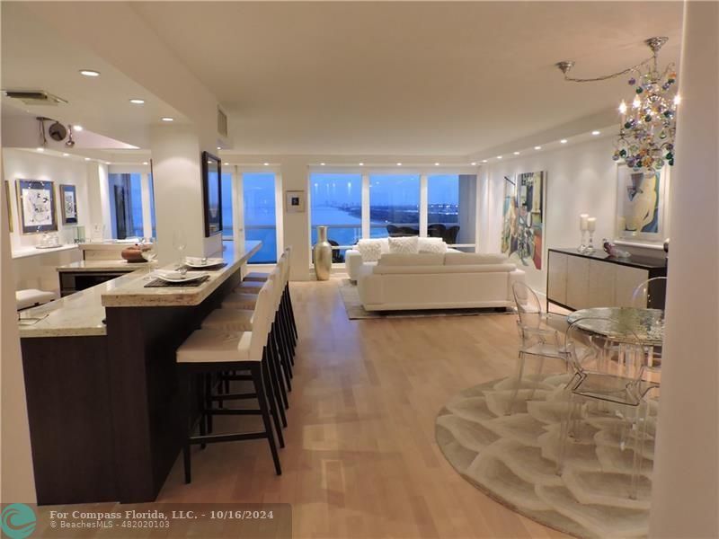 a living room with furniture and a dining table with kitchen view