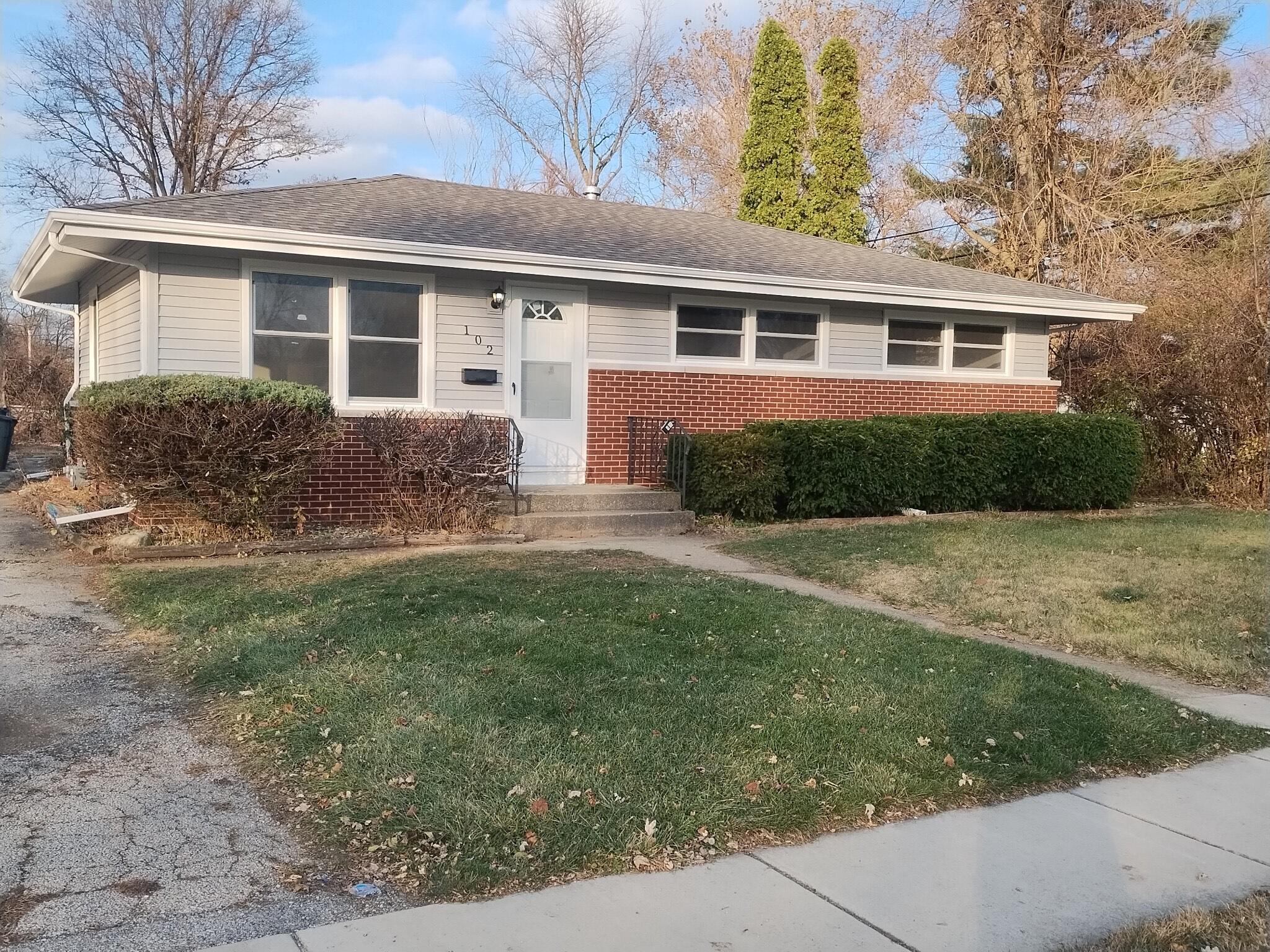 a front view of house with yard and green space