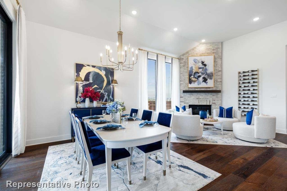 a view of a dining room with furniture a chandelier and wooden floor