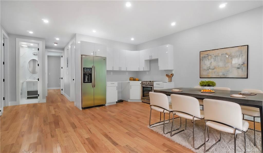 Kitchen featuring white cabinetry, stainless steel appliances, and light hardwood / wood-style floors