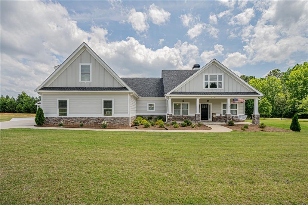 a front view of house with yard and trees in the background