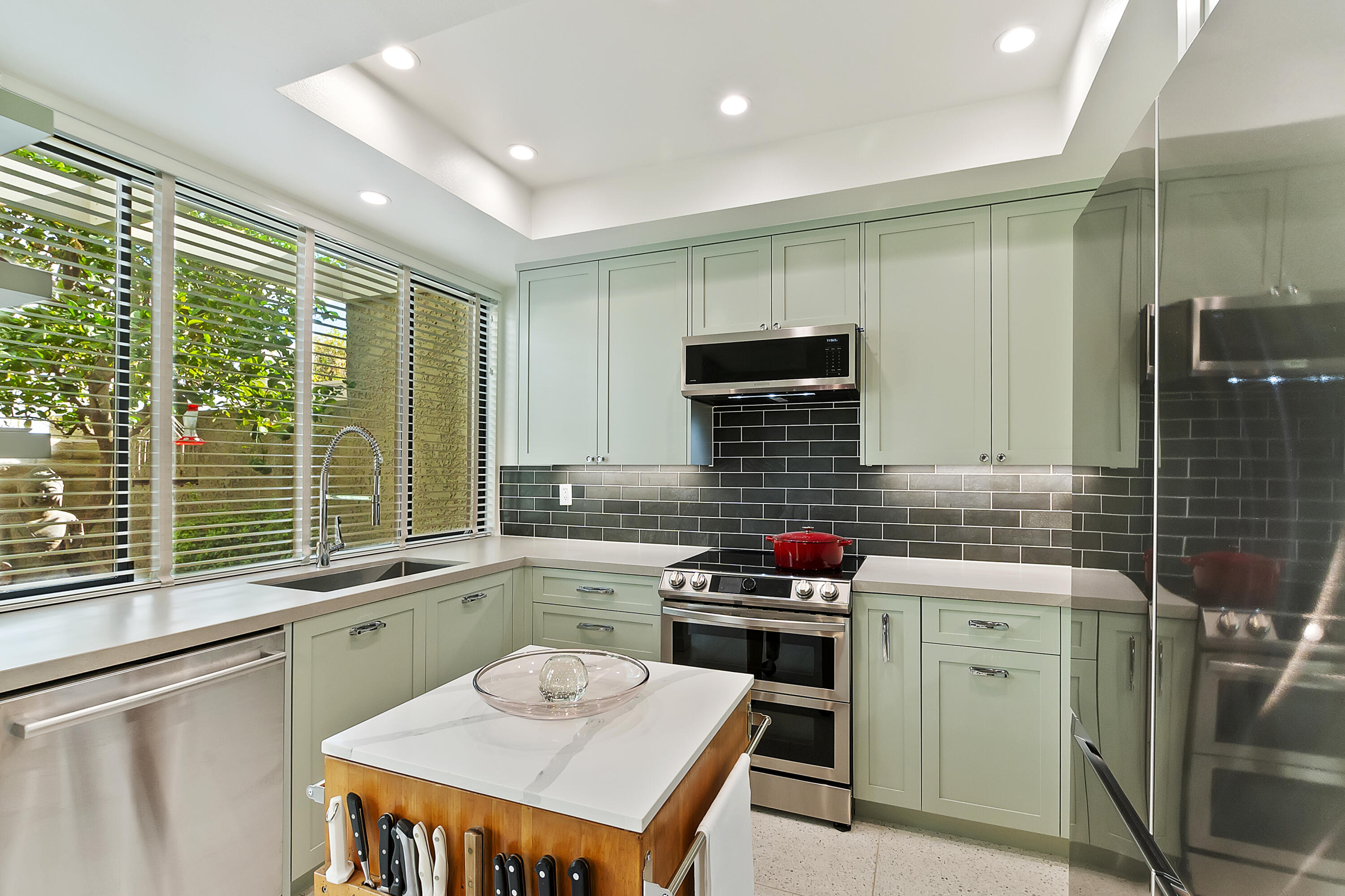 a kitchen that has a sink a stove and chairs