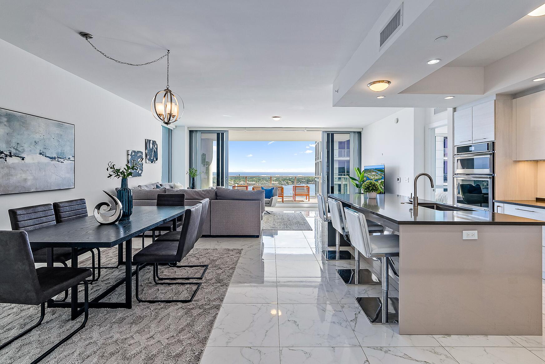 a living room with furniture a chandelier and a dining table