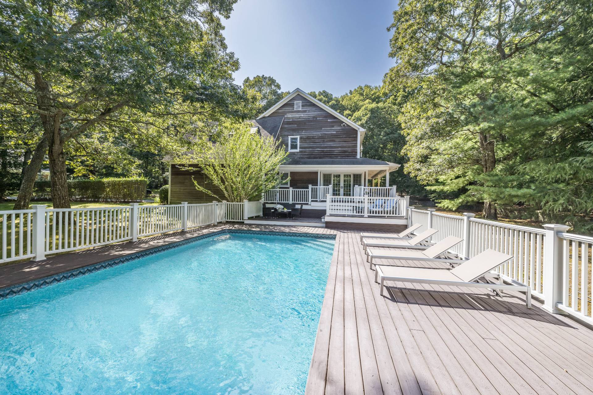 a view of a house with wooden deck and a trees