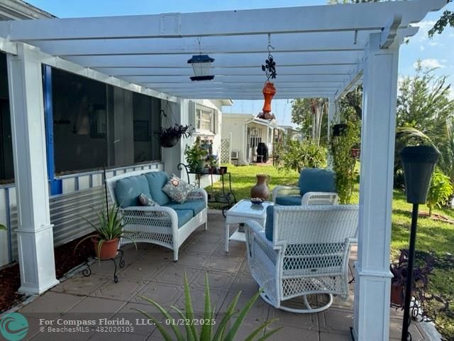 a living room with patio furniture and a potted plant