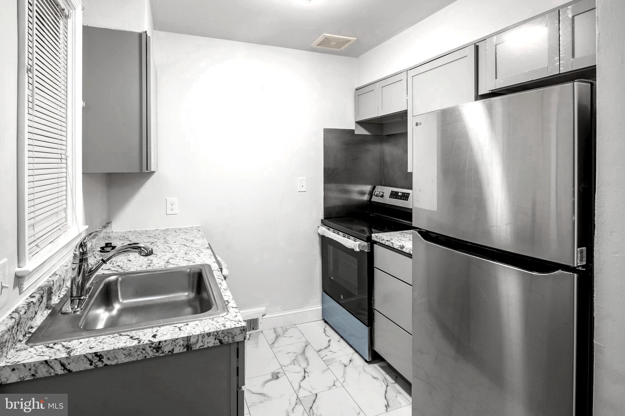 a kitchen with stainless steel appliances granite countertop a refrigerator and a sink