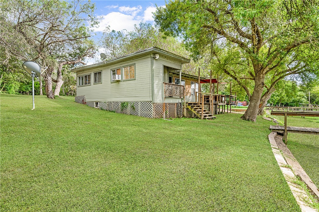 a view of a house with backyard and a tree