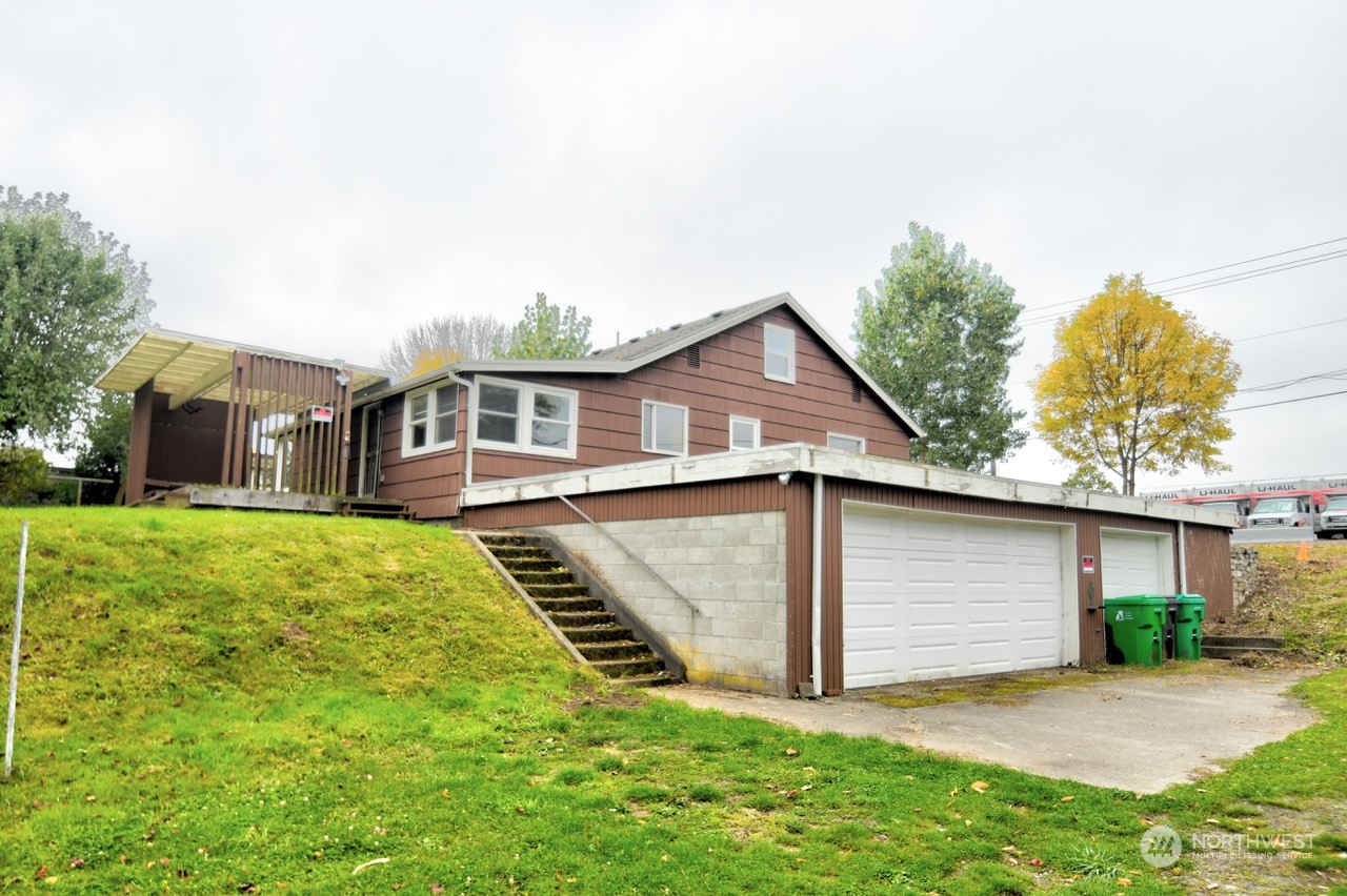 a view of a house with a yard and sitting area