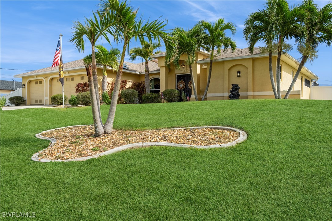 a view of a white house with a big yard and palm trees