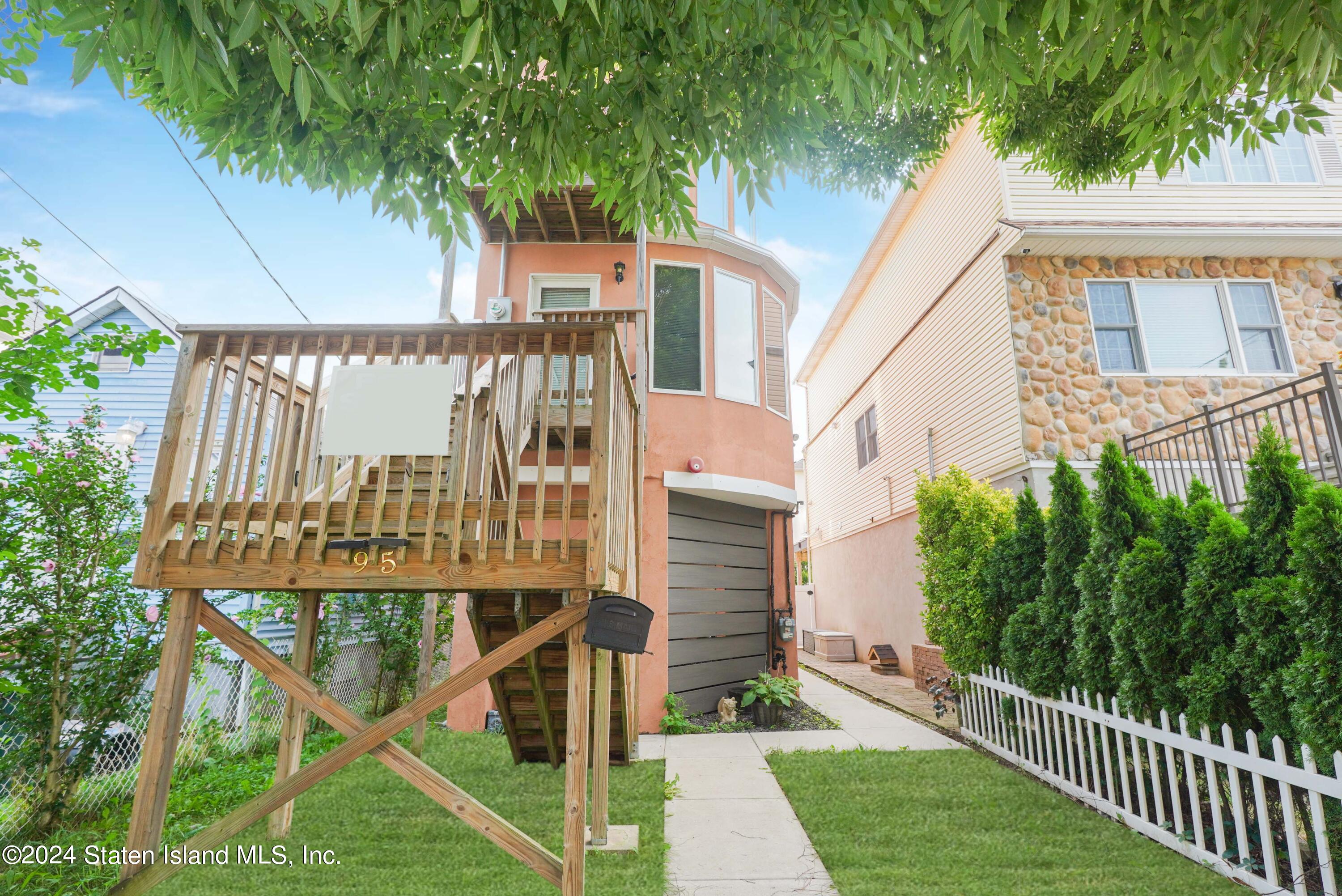 a view of a house with a yard and potted plants