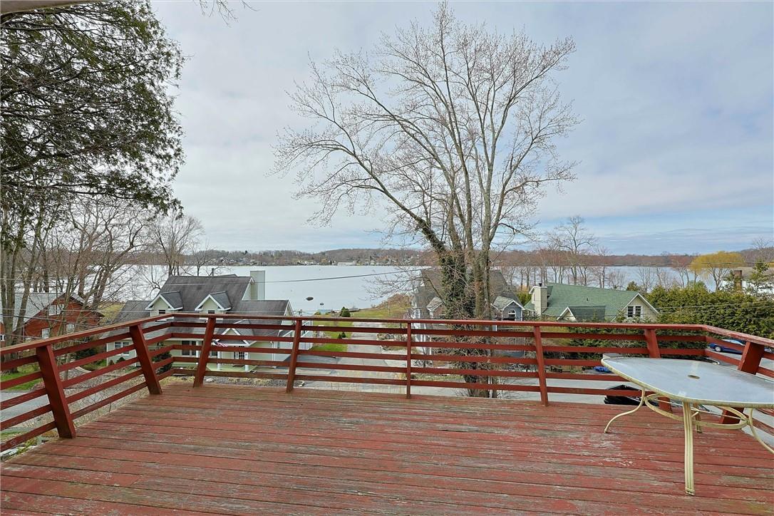 a view of a roof deck with table and chairs a barbeque with wooden floor and fence