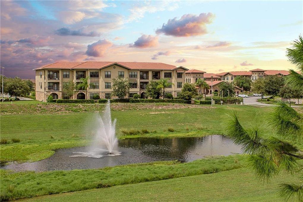 a view of a lake with a big yard and large trees